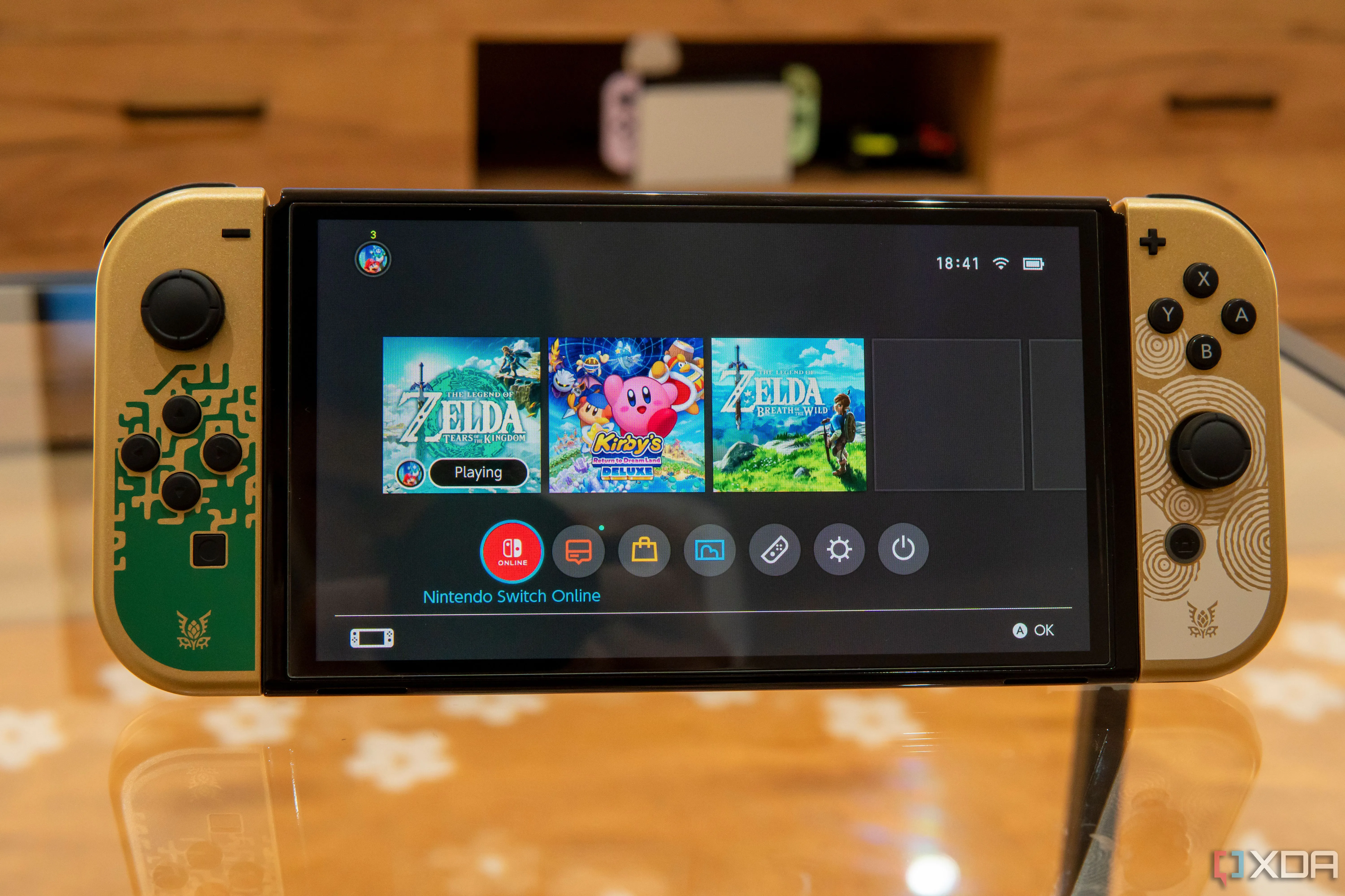 Giao diện chính của Nintendo Switch OLED với một trò chơi đang chạy nền, thể hiện thiết kế sang trọng và trải nghiệm người dùng thân thiện.
