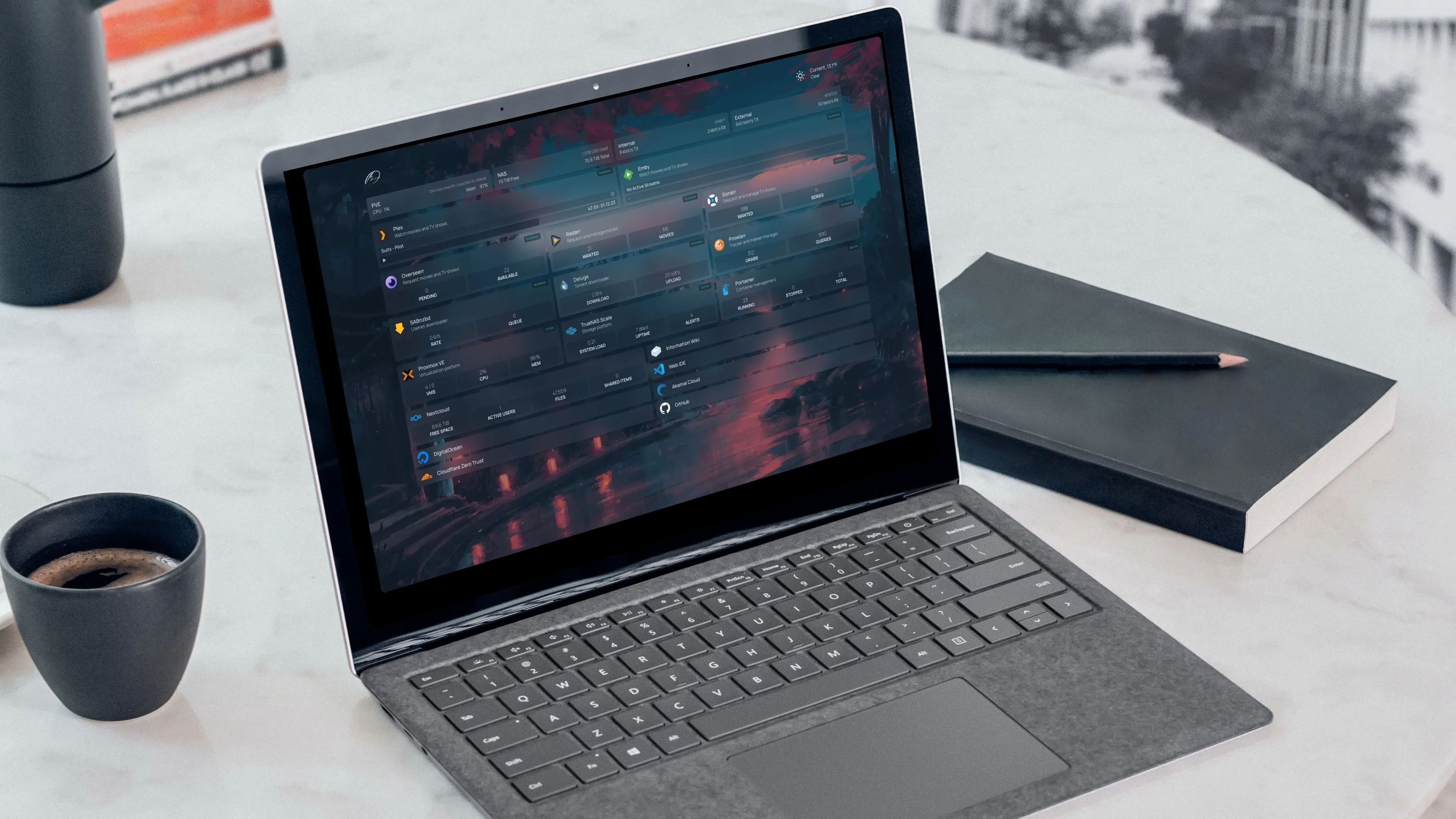Laptop hiển thị bảng điều khiển máy chủ tự lưu trữ với tách cà phê và sổ tay