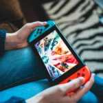 Máy chơi game Nintendo Switch đang được cầm trên tay, minh họa cho việc thử nghiệm cài đặt phần mềm iPhone.