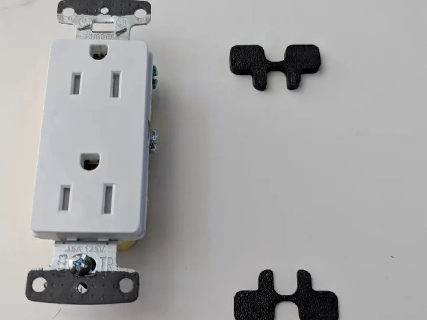 Miếng đệm màu trắng được in 3D để cố định ổ điện, giúp ổ cắm gắn phẳng vào tường