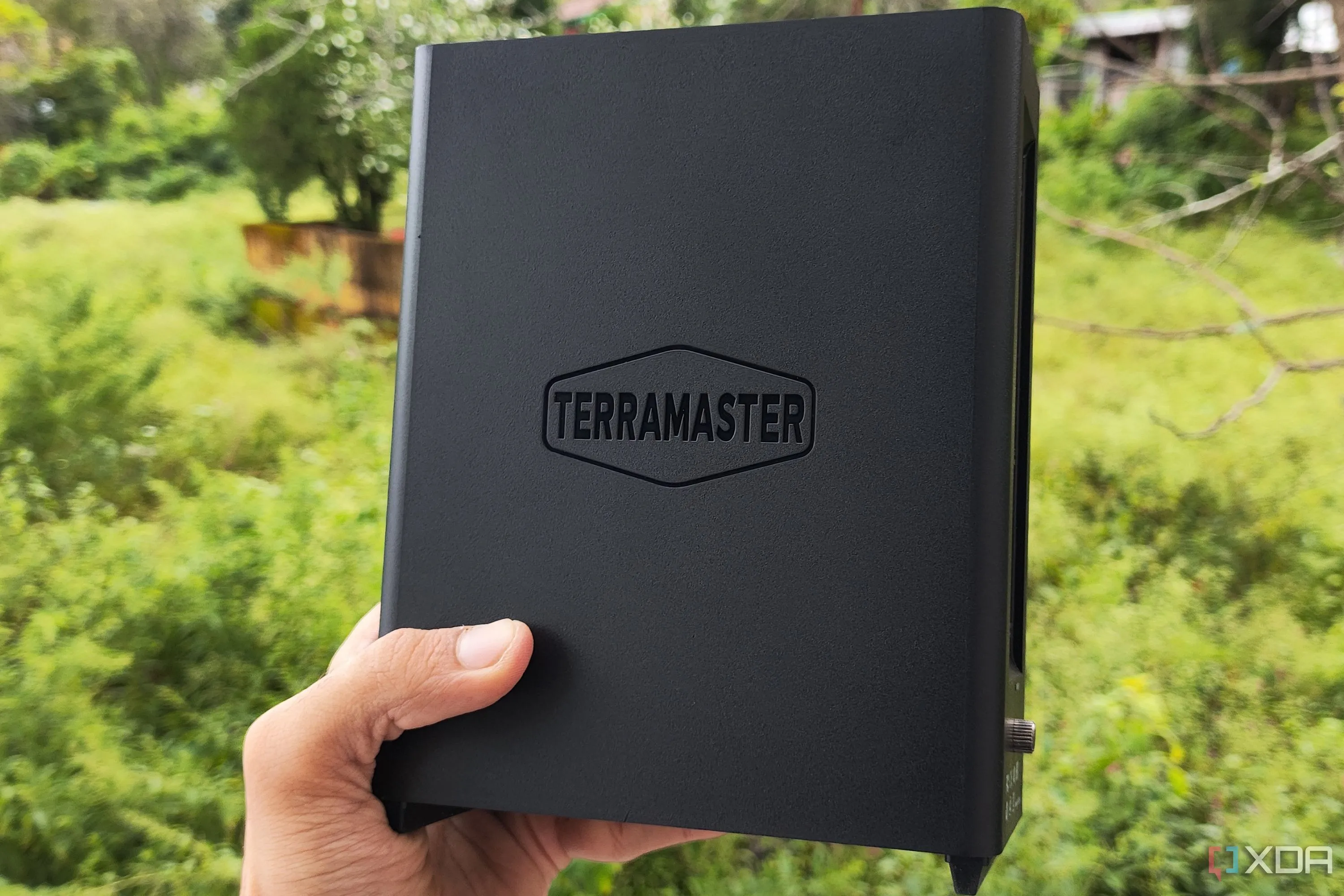 Một người dùng đang cầm thiết bị NAS TerraMaster F8 SSD Plus, cho thấy kích thước nhỏ gọn của hệ thống lưu trữ flash.