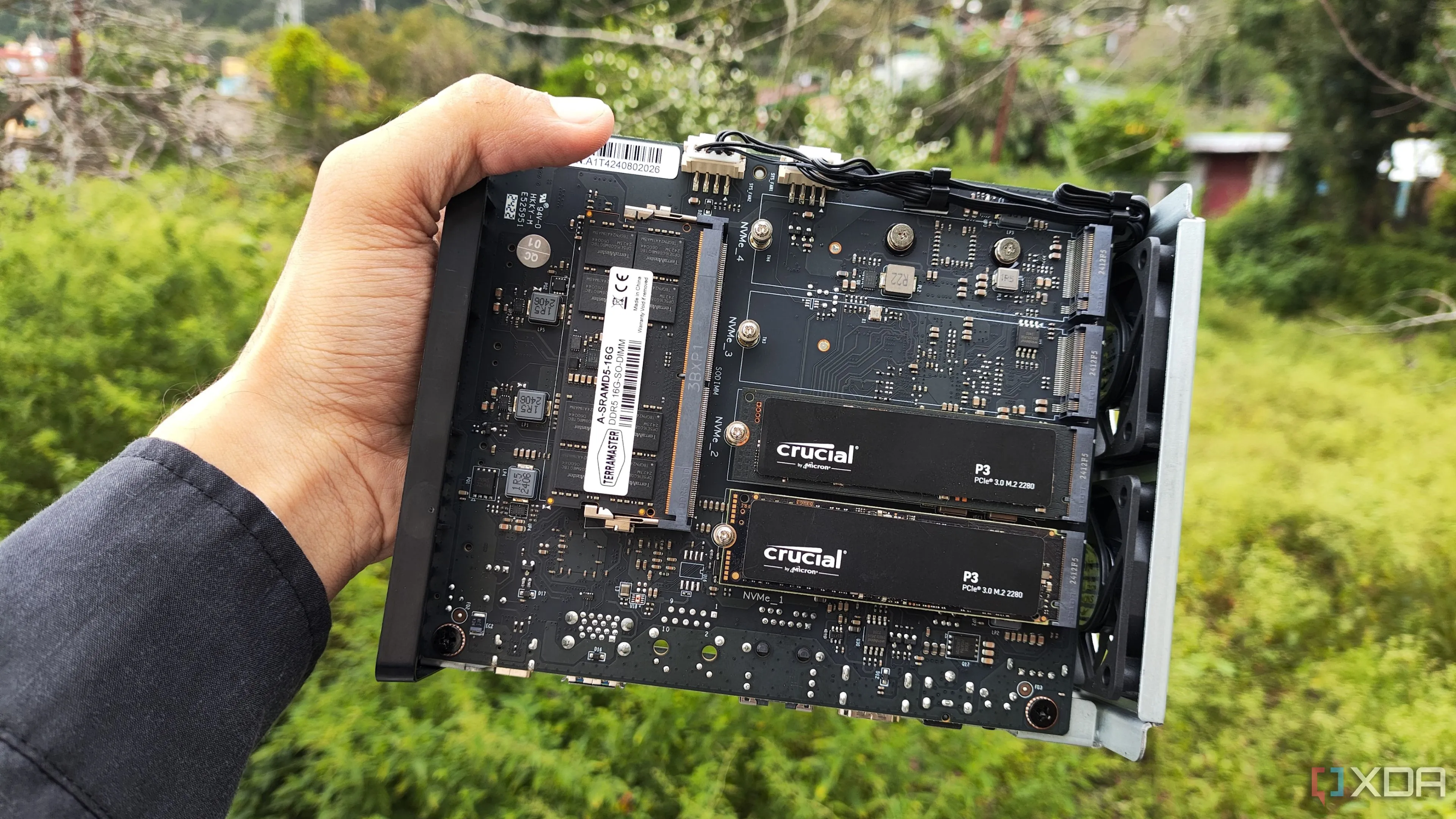 Người đang cầm một chiếc TerraMaster F8 SSD Plus với hai ổ SSD PCIe 3 được lắp vào NAS