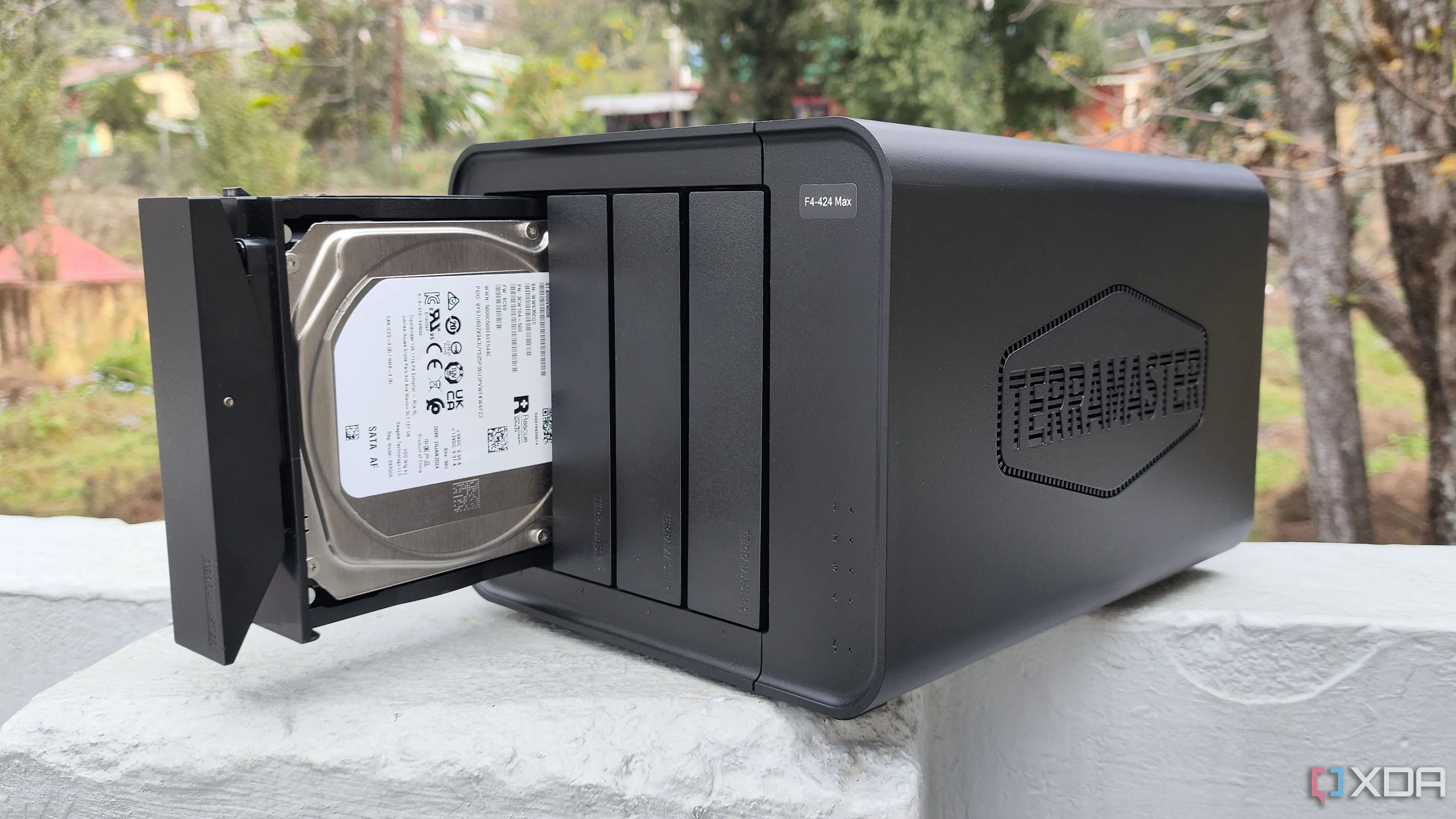 Người dùng đang cầm thiết bị NAS TerraMaster F4-424 Max, minh họa kích thước và thiết kế của mẫu NAS 4 khay cao cấp.
