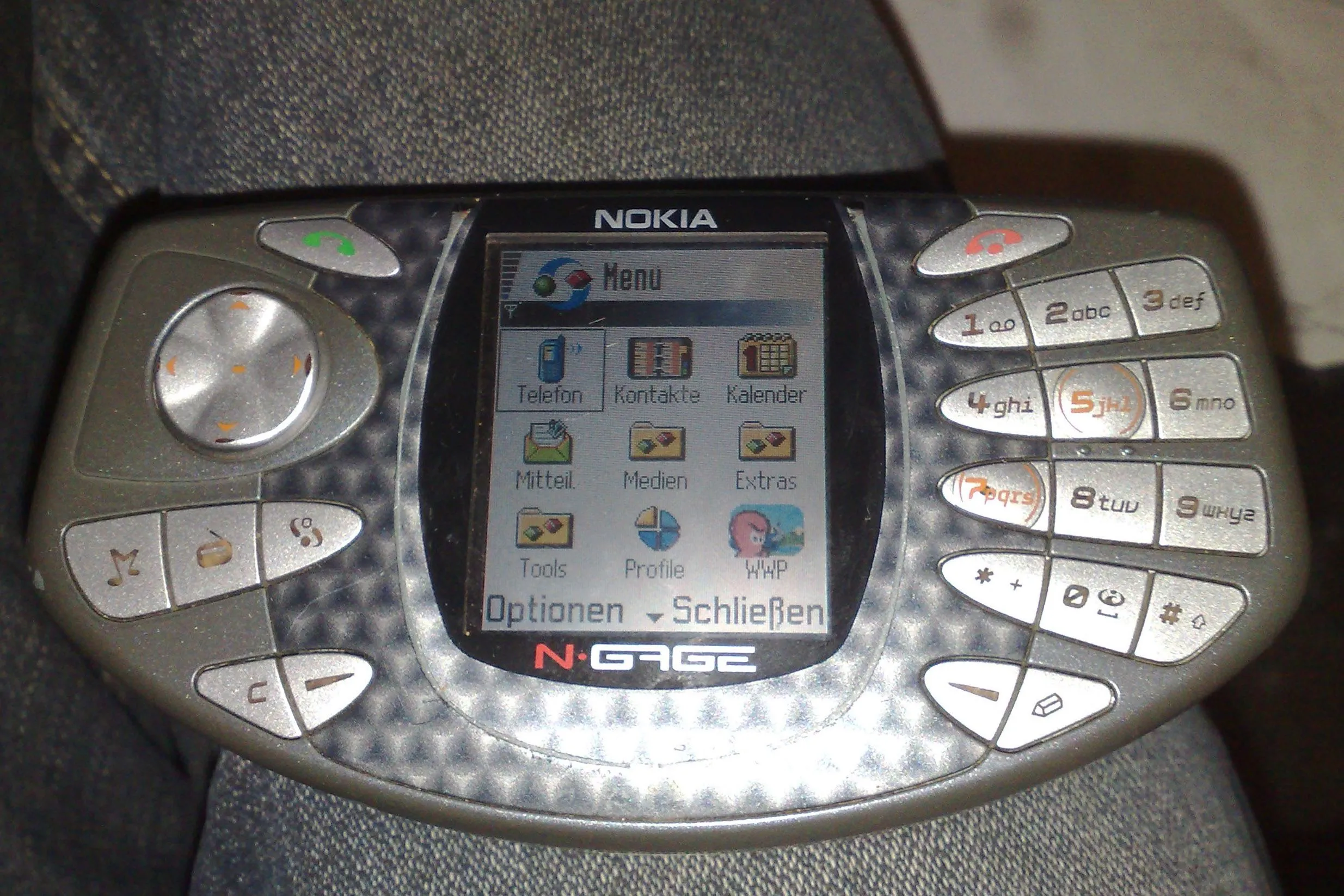 Nokia N-Gage phiên bản đầu tiên, được đặt trên một bề mặt, hiển thị thiết kế độc đáo hình &quot;taco&quot;