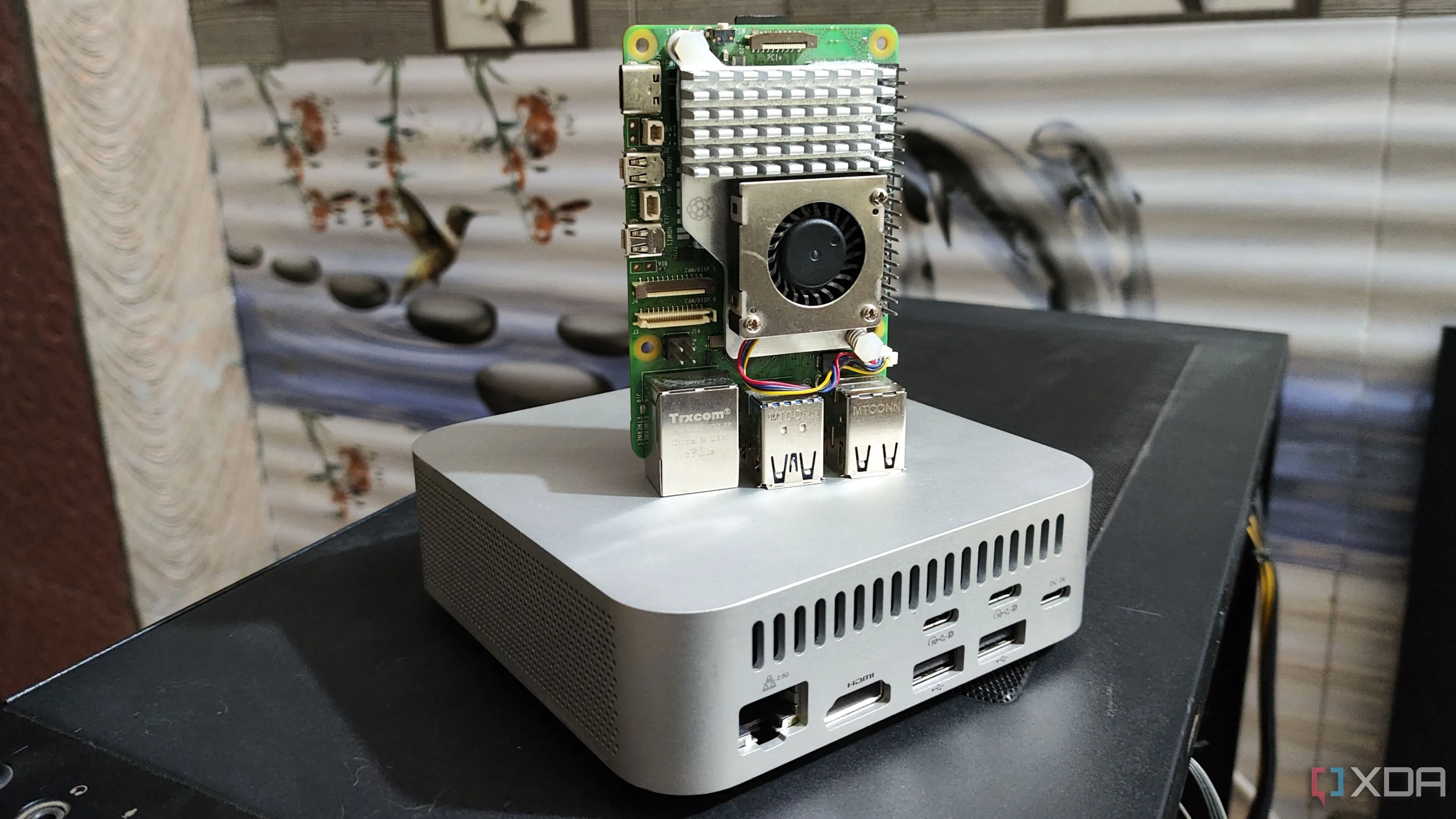 Raspberry Pi 5 đặt trên một hệ thống NAS Aiffro K100, thể hiện kích thước nhỏ gọn và khả năng tích hợp trong các dự án NAS tiết kiệm năng lượng