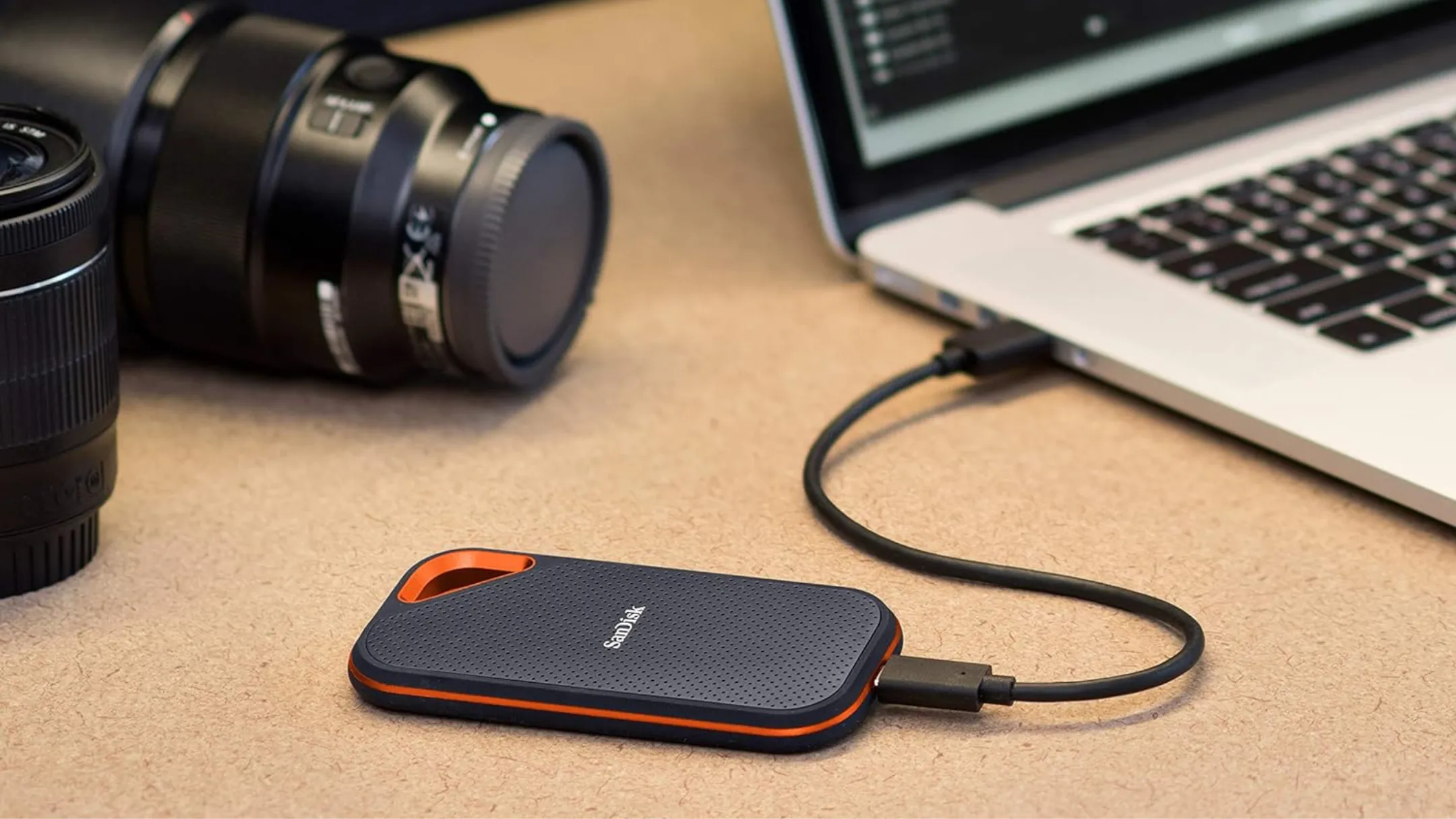 SanDisk Extreme PRO Portable SSD đặt cạnh laptop và máy ảnh, minh họa khả năng di động và tính đa dụng.